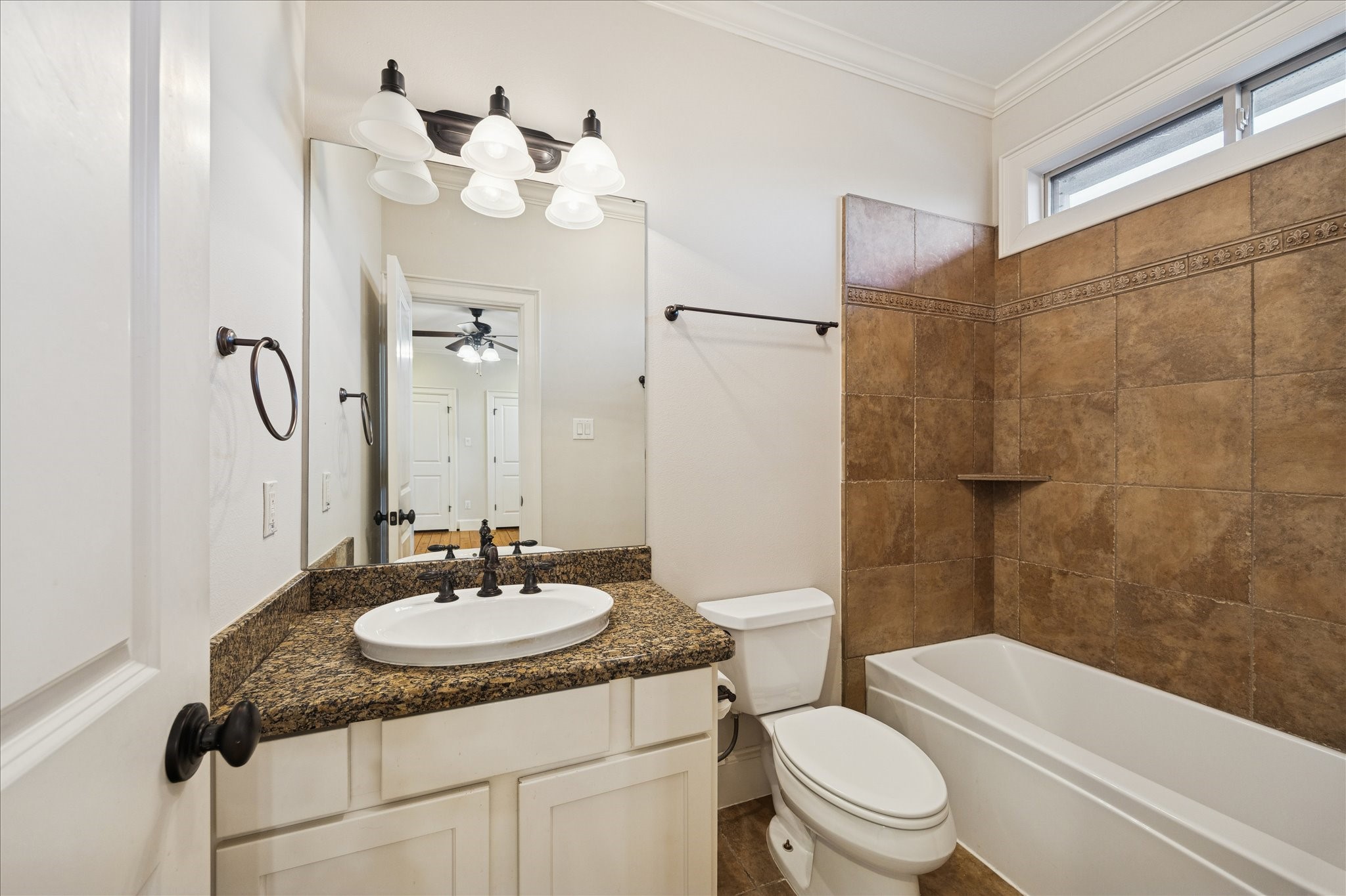 840 Alexander Street Houston, TX 77007 - Photo 28 of 39 The apartment bathroom features a granite countertop with an oval sink, elegant lighting, and a tiled shower-tub combo with natural lighting.