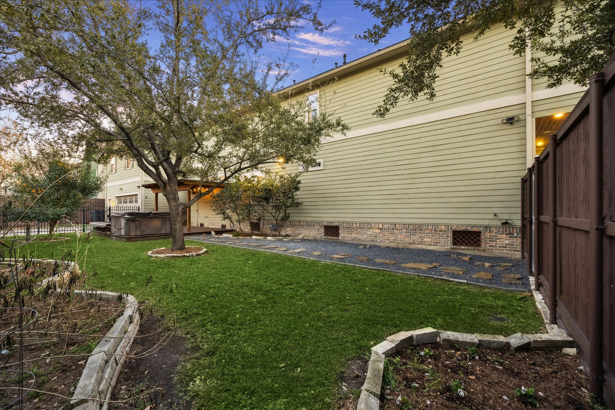 840 Alexander Street Houston, TX 77007 - Photo 31 of 39 A view of the luscious side yard from the far left corner of the lot. This meticulously maintained yard features new sprinkler system with French drains that connected to the street drainage. Enjoy soaking in the sun with a fresh orange in the included hot tub.