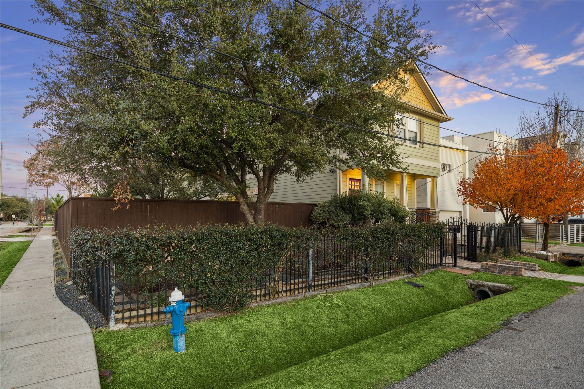 840 Alexander Street Houston, TX 77007 - Photo 7 of 39 Double lot two-story home with a welcoming front porch, surrounded by mature trees and a well-maintained garden. Features a fenced yard, a vibrant autumn tree, and a convenient sidewalk location. Access the adjacent street (9th Street) access through the automatic driveway gate into your oversized garage and garage apartment.