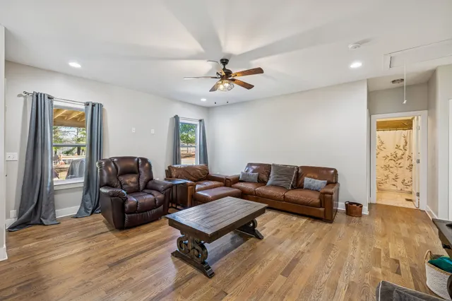 a living room with furniture and a ceiling fan
