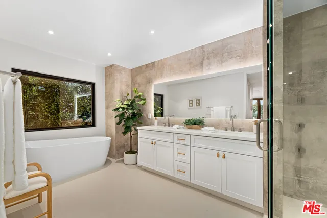 a bathroom with a granite countertop sink mirror and bathtub