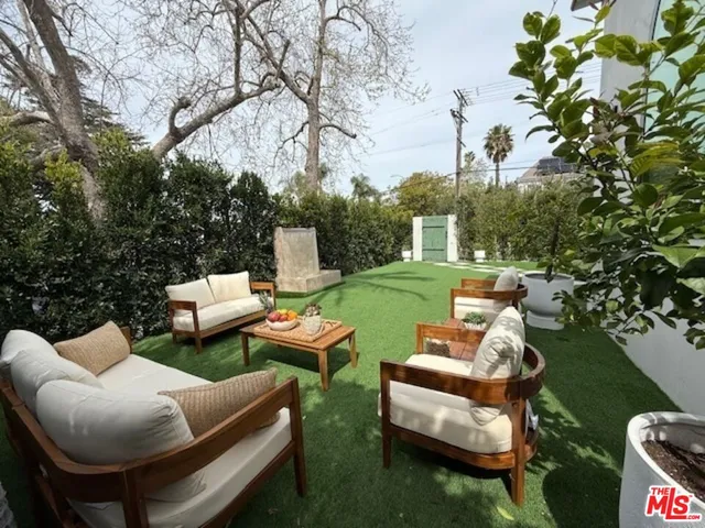 a view of a patio with couches table and chairs and potted plants