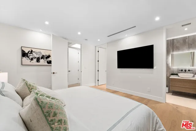 a bedroom with a bed and a flat screen tv