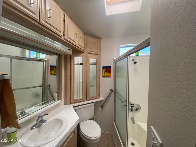 a bathroom with a sink a toilet a mirror and shower