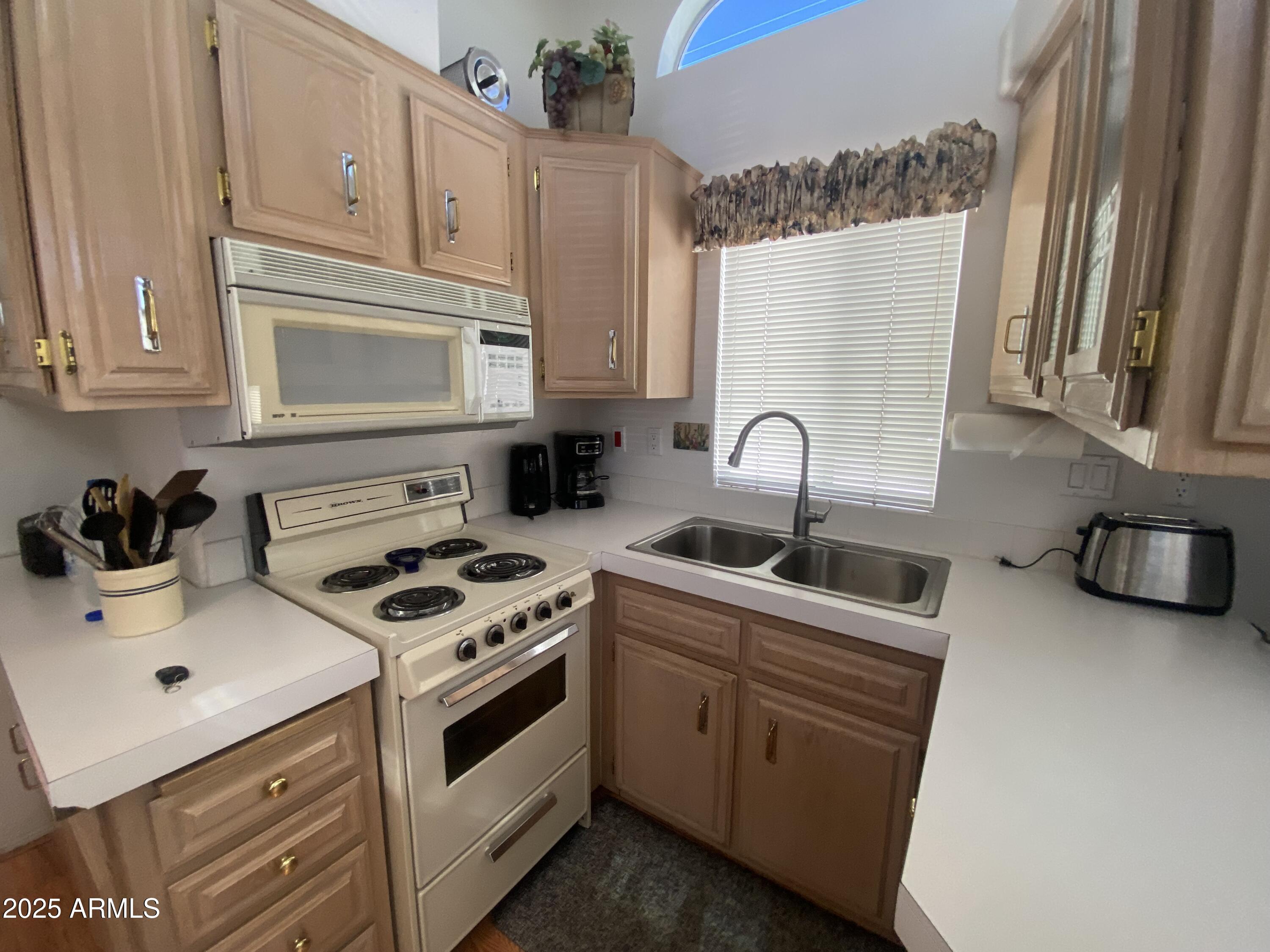 2072 West Klamath Avenue Apache Junction, AZ 85119 - Photo 9 of 25 a kitchen with stainless steel appliances granite countertop a sink stove and cabinets