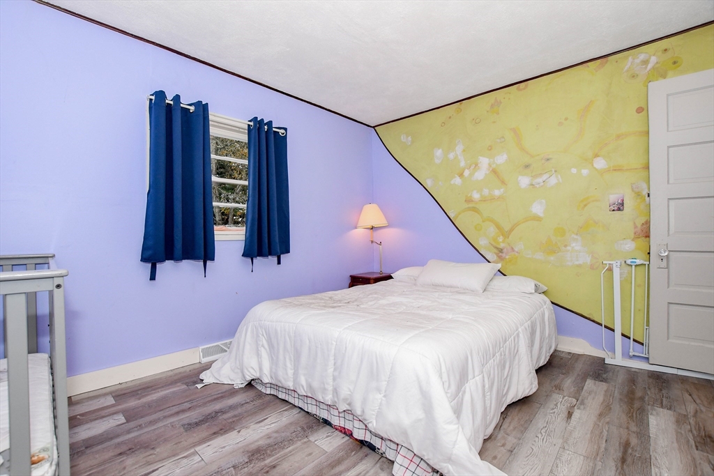 6 Gilbert Way Wareham, MA 02571 - Photo 20 of 42 a bedroom with a bed and wooden floor