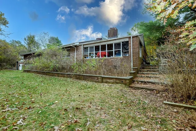 a front view of a house with a yard and potted plants