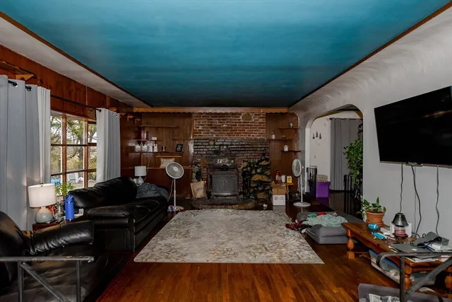 a living room with furniture a flat screen tv and a floor to ceiling window