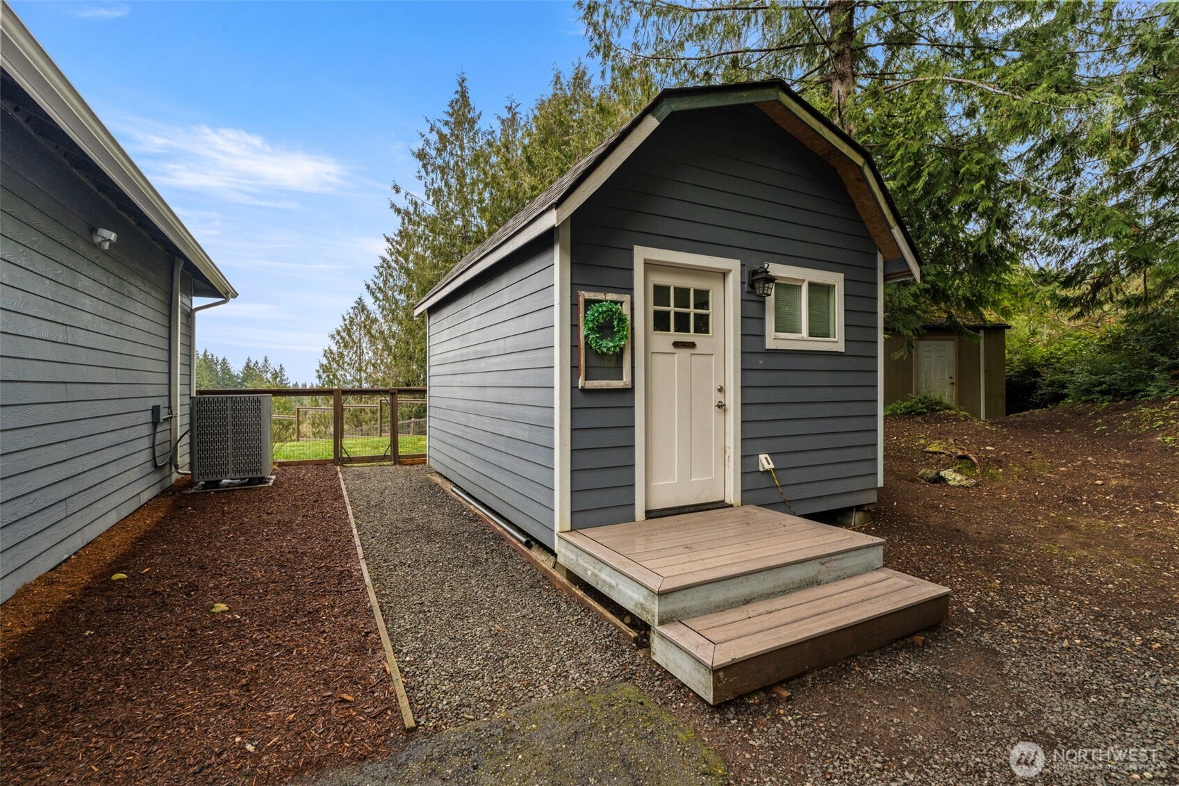 9916 Dishman Road Northwest Bremerton, WA 98312 - Photo 29 of 40 a view of a small house with a small yard plants and large tree