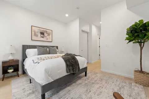 a bedroom with a bed and a potted plant