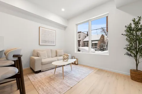 a kitchen with stainless steel appliances granite countertop a refrigerator a sink a stove a dining table and chairs with wooden floor