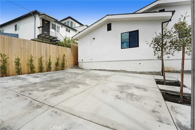 a view of a white house with wooden fence