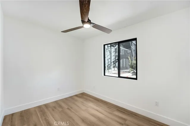 an empty room with a window and a ceiling fan