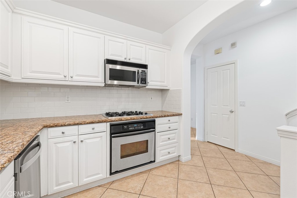72 Clouds View Irvine, CA 92603 - Photo 15 of 43 a kitchen with granite countertop white cabinets and stainless steel appliances