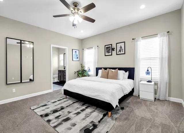 a spacious bedroom with a bed and a chandelier