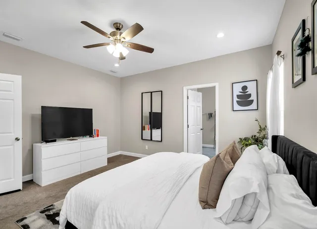 a bedroom with a bed and a flat screen tv