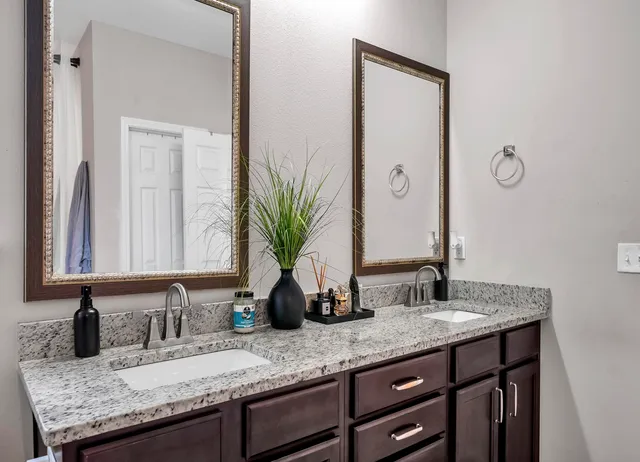 a bathroom with a granite countertop sink and a mirror