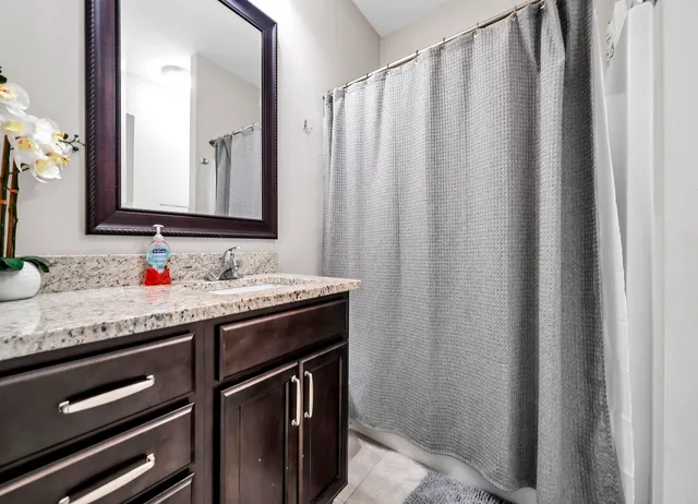 a bathroom with a granite countertop sink and a mirror