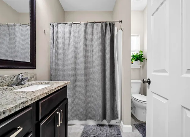 a bathroom with a granite countertop sink and a mirror