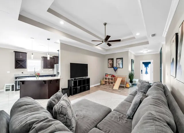 a living room with furniture kitchen view and a flat screen tv
