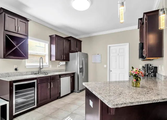 a kitchen with stainless steel appliances granite countertop a sink refrigerator and cabinets