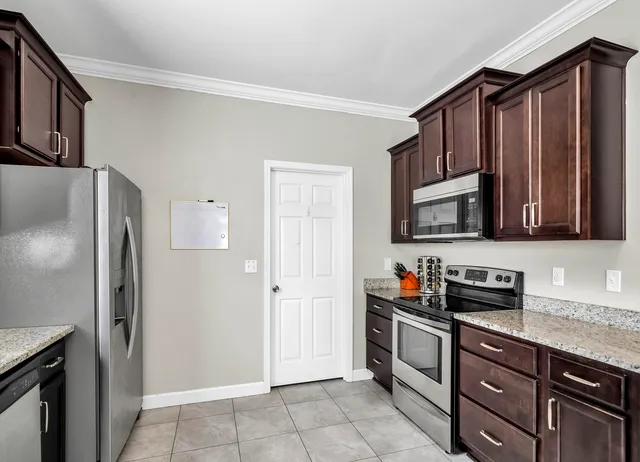 a kitchen with stainless steel appliances granite countertop a refrigerator and a sink