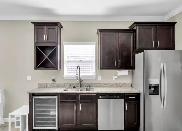 a kitchen with stainless steel appliances granite countertop a sink and a refrigerator