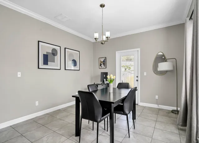 a dining room with wooden floor a chandelier a wooden table and chairs