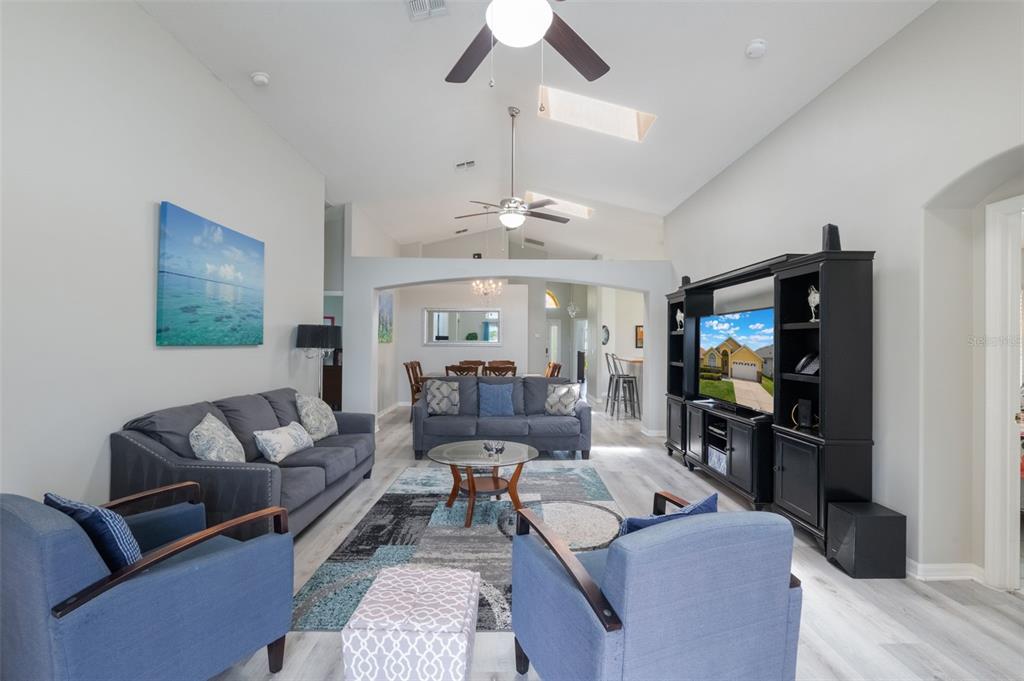 2685 Oneida Loop Kissimmee, FL 34747 - Photo 13 of 54 a living room with furniture a chandelier and a flat screen tv