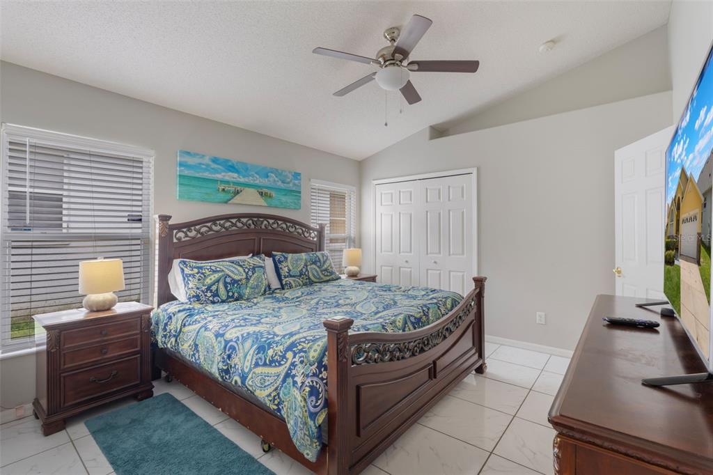 2685 Oneida Loop Kissimmee, FL 34747 - Photo 15 of 54 a bedroom with a bed and a flat tv screen on the dresser