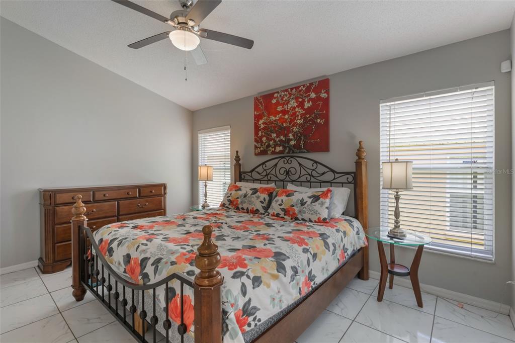 2685 Oneida Loop Kissimmee, FL 34747 - Photo 18 of 54 a bedroom with a bed and a chandelier