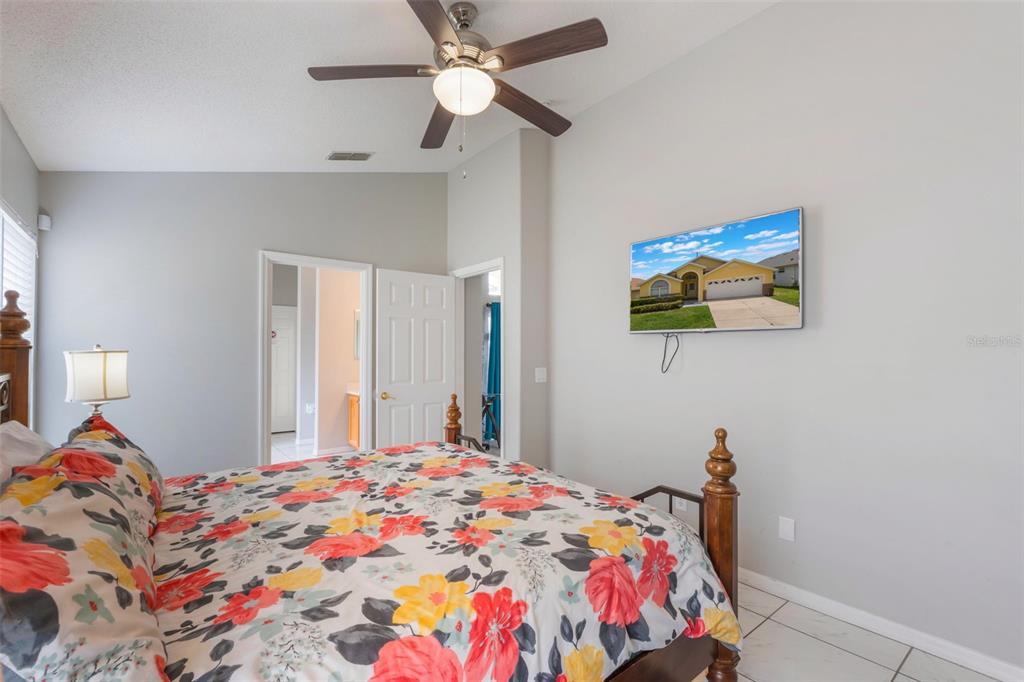 2685 Oneida Loop Kissimmee, FL 34747 - Photo 19 of 54 a bedroom with a bed and a chandelier