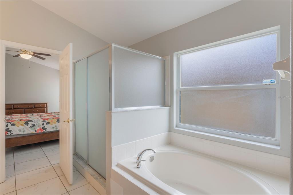 2685 Oneida Loop Kissimmee, FL 34747 - Photo 21 of 54 a bathroom with a tub and a shower