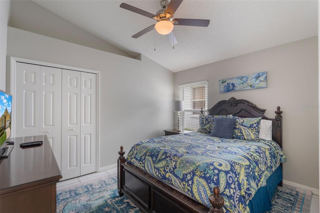 2685 Oneida Loop Kissimmee, FL 34747 - Photo 22 of 54 a bedroom with a bed and a flat tv screen on dresser
