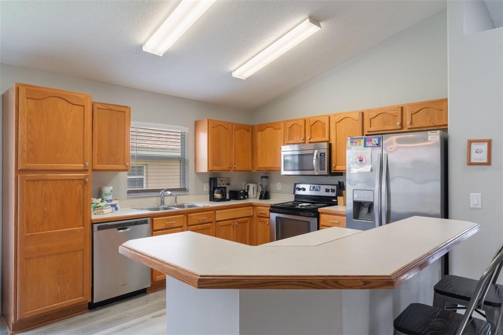 2685 Oneida Loop Kissimmee, FL 34747 - Photo 5 of 54 a kitchen with kitchen island a sink stove and refrigerator