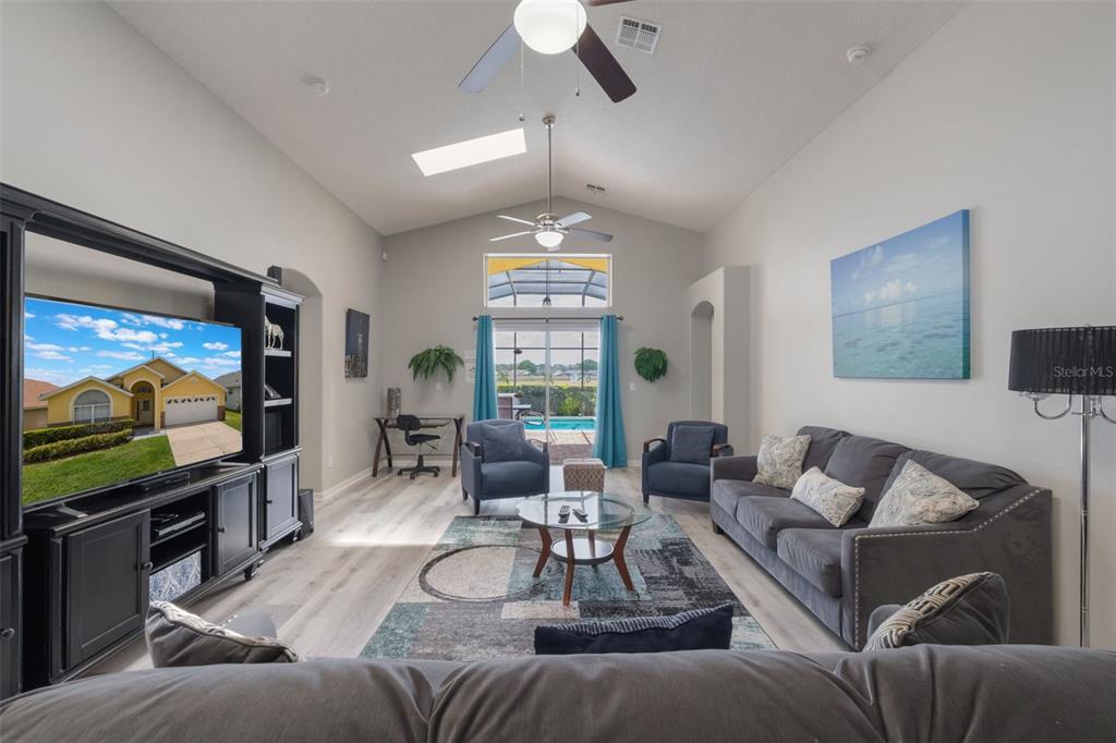 2685 Oneida Loop Kissimmee, FL 34747 - Photo 10 of 54 a living room with furniture a chandelier and a flat screen tv
