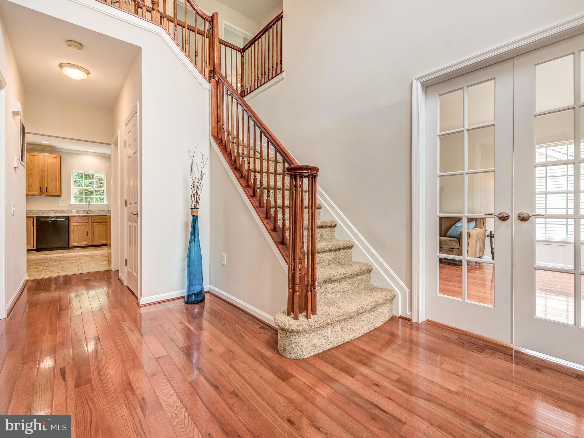 6413 Spring Forest Road Frederick, MD 21701 - Photo 3 of 30 Curved staircase with french doors to Living Room.