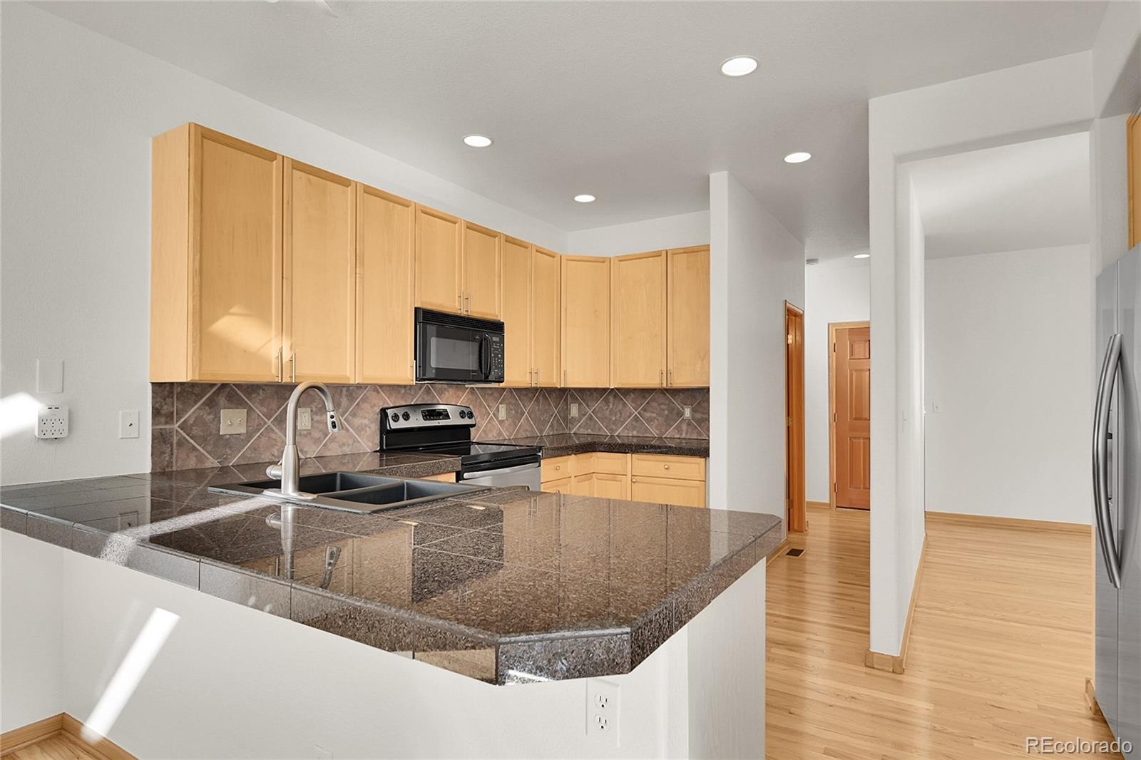 671 Trailside Drive Golden, CO 80401 - Photo 15 of 39 a kitchen with stainless steel appliances granite countertop a sink a stove and a refrigerator