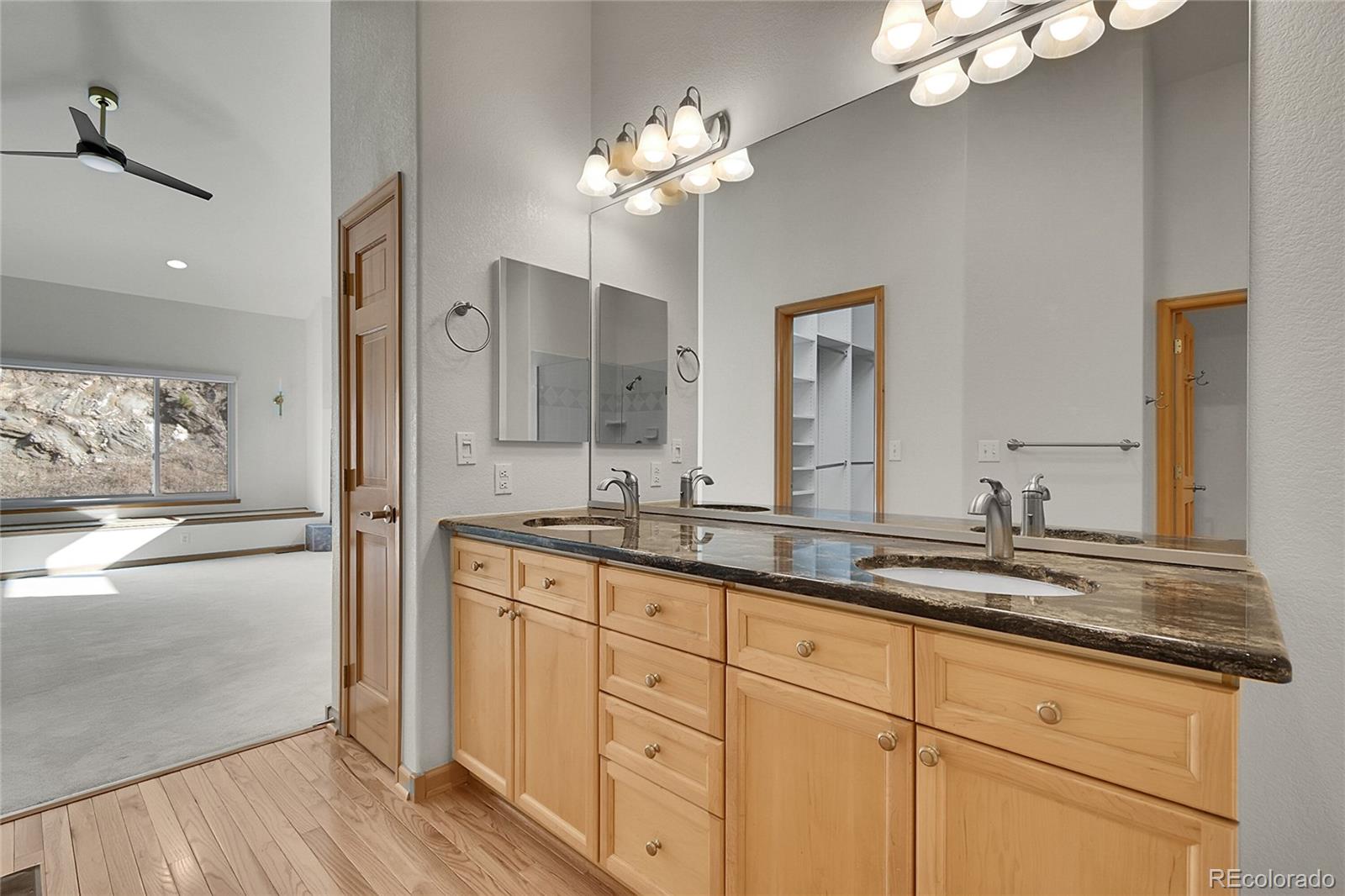 671 Trailside Drive Golden, CO 80401 - Photo 21 of 39 a spacious bathroom with a granite countertop sink a mirror and a shower