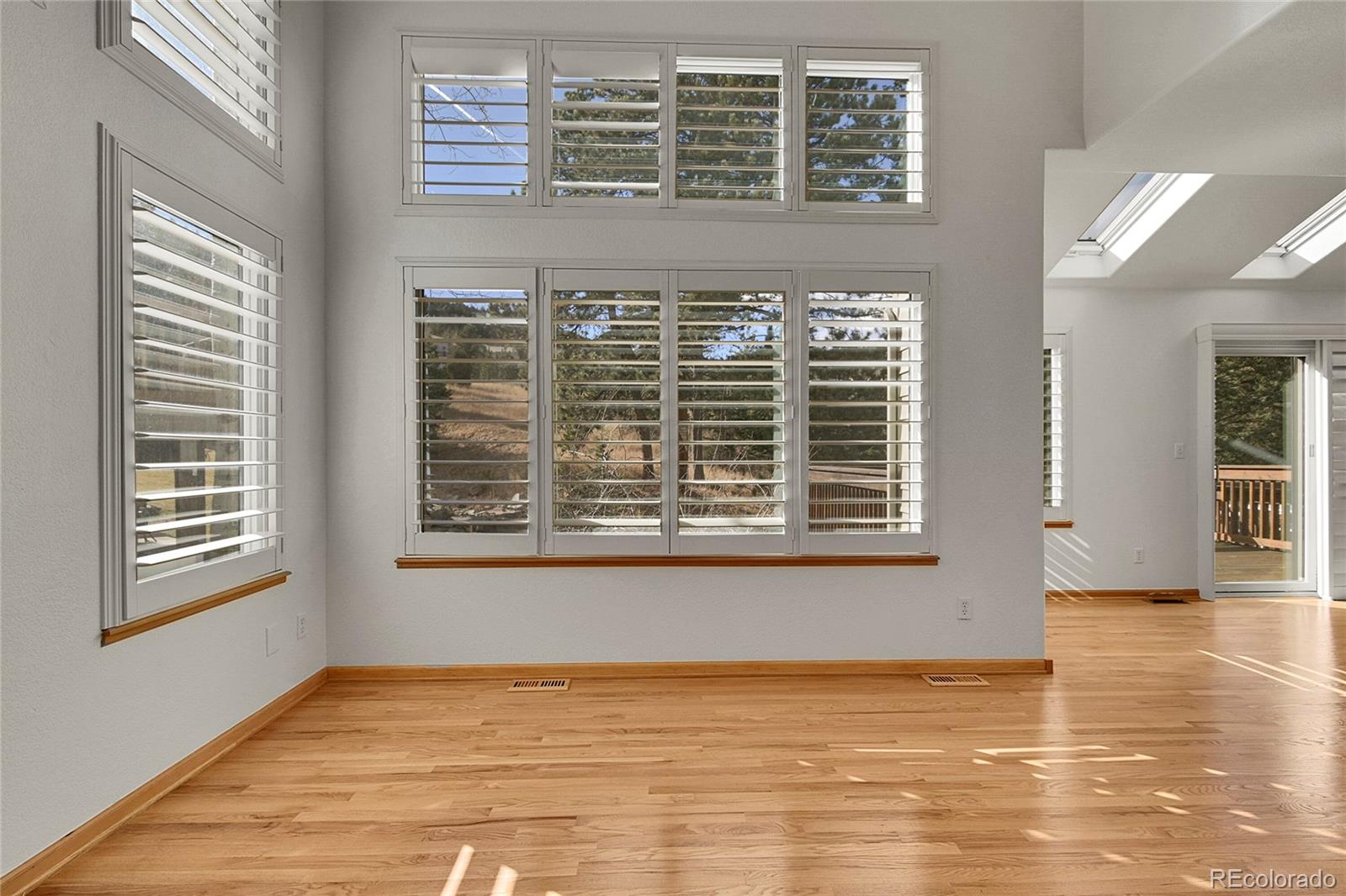 671 Trailside Drive Golden, CO 80401 - Photo 6 of 39 a view of an empty room with wooden floor and a window
