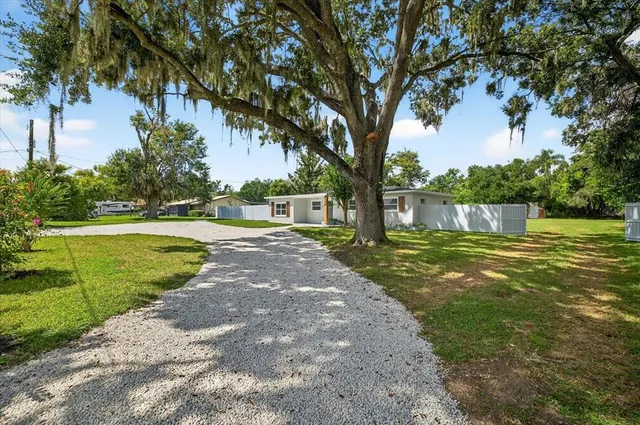 a view of an empty room with wooden floor and window
