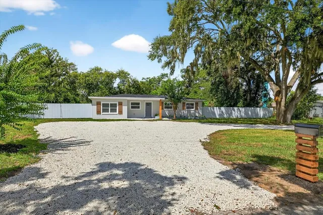 a large kitchen with a refrigerator a sink dishwasher a stove and white cabinets with wooden floor