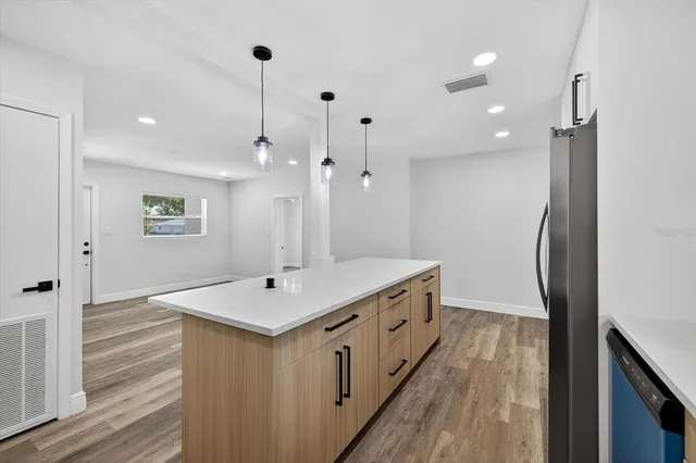 an empty room with wooden floor ceiling fan and windows