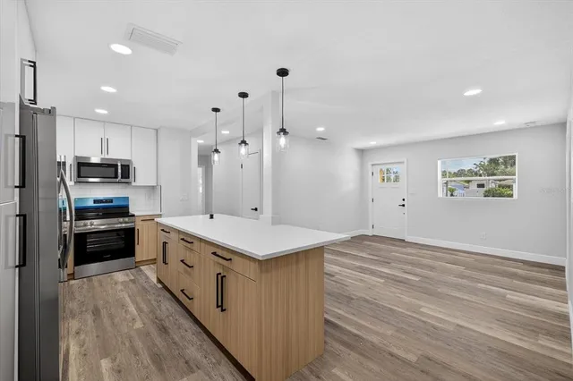 a view of wooden floor and chandelier fan in a room