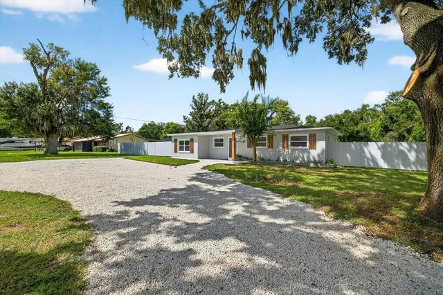 a front view of house with yard and trees in the background