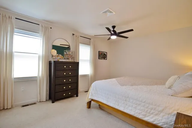 a bathroom with a granite countertop sink vanity mirror and toilet