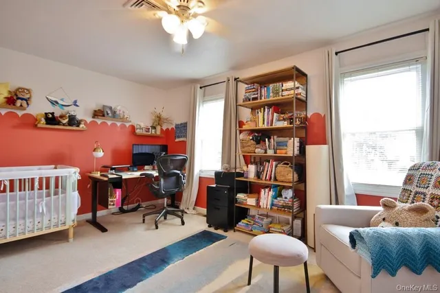 a living room with furniture a rug and a book shelf