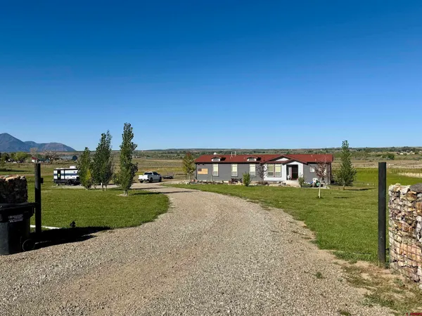 a view of a house with a yard and a street