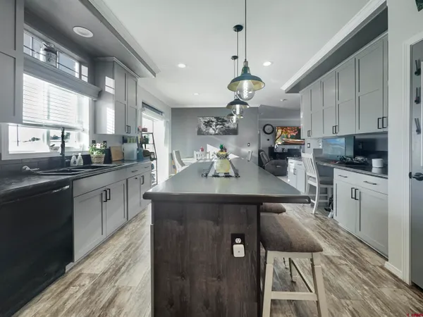 a kitchen with kitchen island granite countertop a sink cabinets and stainless steel appliances