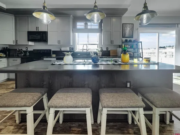 a kitchen with stainless steel appliances granite countertop a table chairs sink and cabinets
